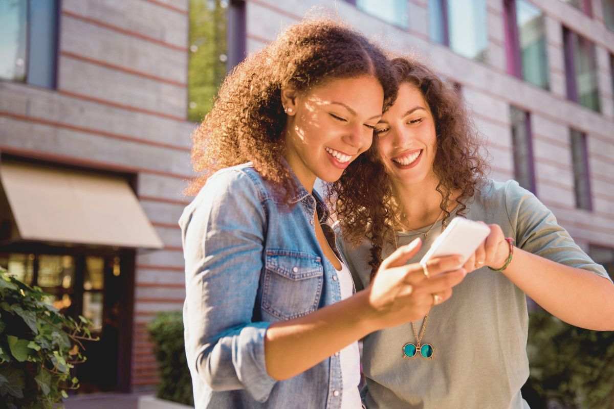 Ragazze sorridenti guardano smartphone